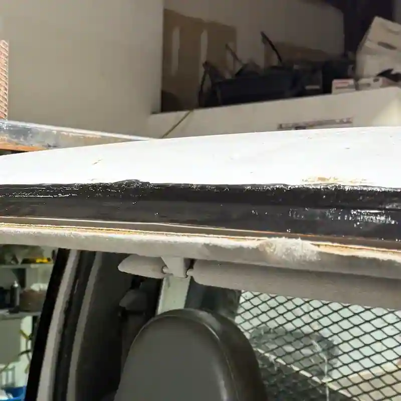 Surface rust exposed around windshield frame before repair in Omaha