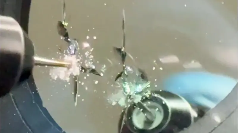 Windshield rock chip being drilled for proper resin fill during repair.